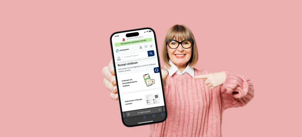 Eine lächelnde Frau hält ein Smartphone mit der Seite „Rezept einlösen“ der Winckelmann Apotheke Stendal und zeigt darauf.