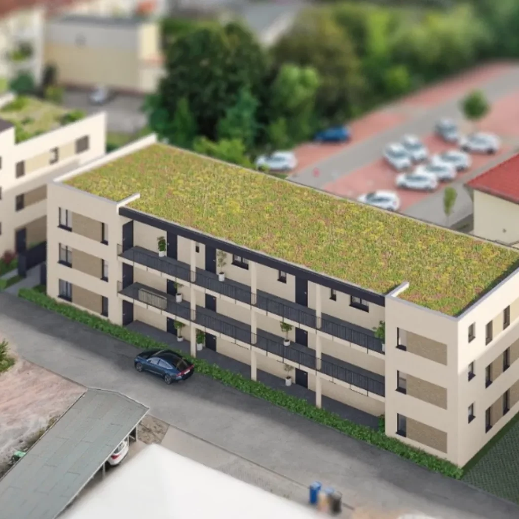 Modellaufnahme eines dreistöckigen Mehrfamilienhauses mit begrüntem Dach, Balkonen und einem Parkplatz davor.