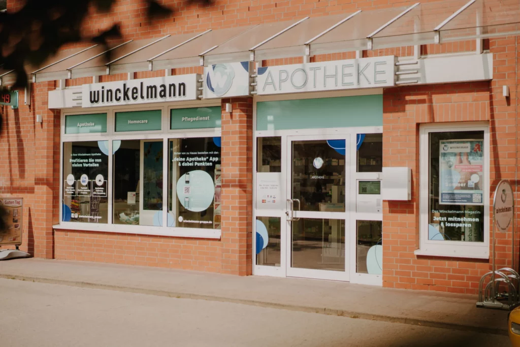 Außenansicht einer Winckelmann Apotheke Seehausen in einem Backsteingebäude mit den Angeboten Apotheke, Homecare und Pflegedienst.