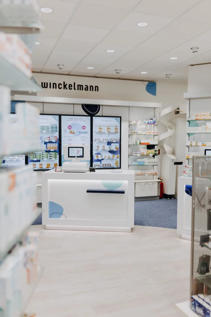 Der Verkaufsraum einer Winckelmann Apotheke mit heller Beratungstheke und Produktregalen im Hintergrund.